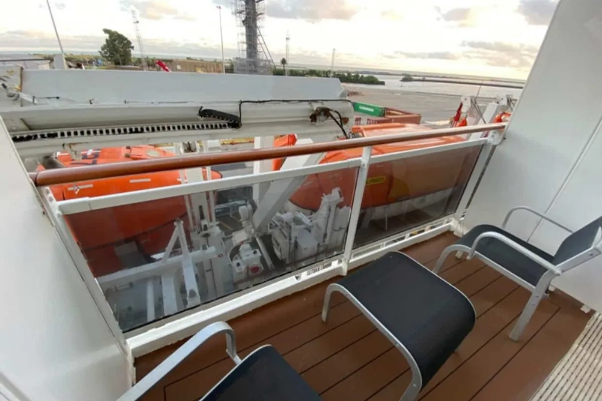 Balcón con vista parcialmente obstruida por botes salvavidas en la cabina 8141 del MSC Fantasia