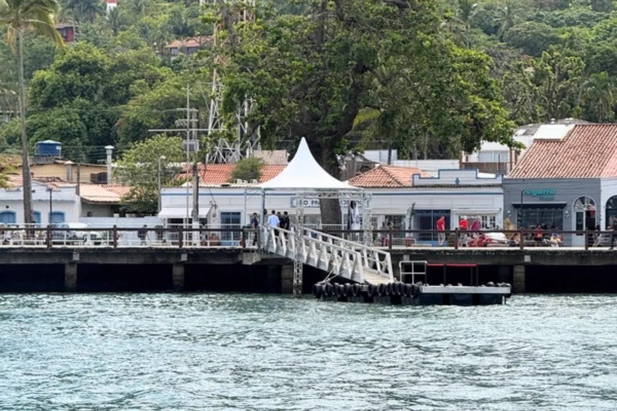 Muelle con pasarela y carpa blanca visto desde el agua en un puerto de crucero